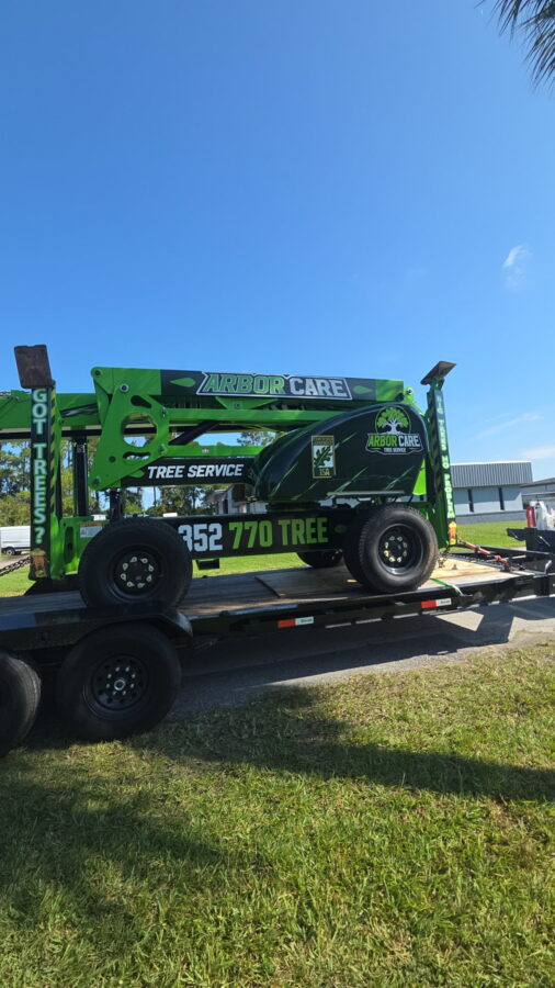 Arbor Care Tree Service towable lift on a trailer, marked with the ISA Certified Arborist seal and 352-770-TREE